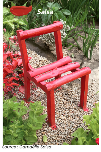 Peinture extérieur chaise rouge vif avec des plantes vertes en arrière-plan