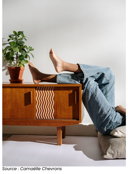 Buffet vintage en bois avec des pieds croisés en l’air, décoré de motifs de chevrons de Camaëlle. Exemple inspirant de rénovation pour apporter une touche moderne et graphique.